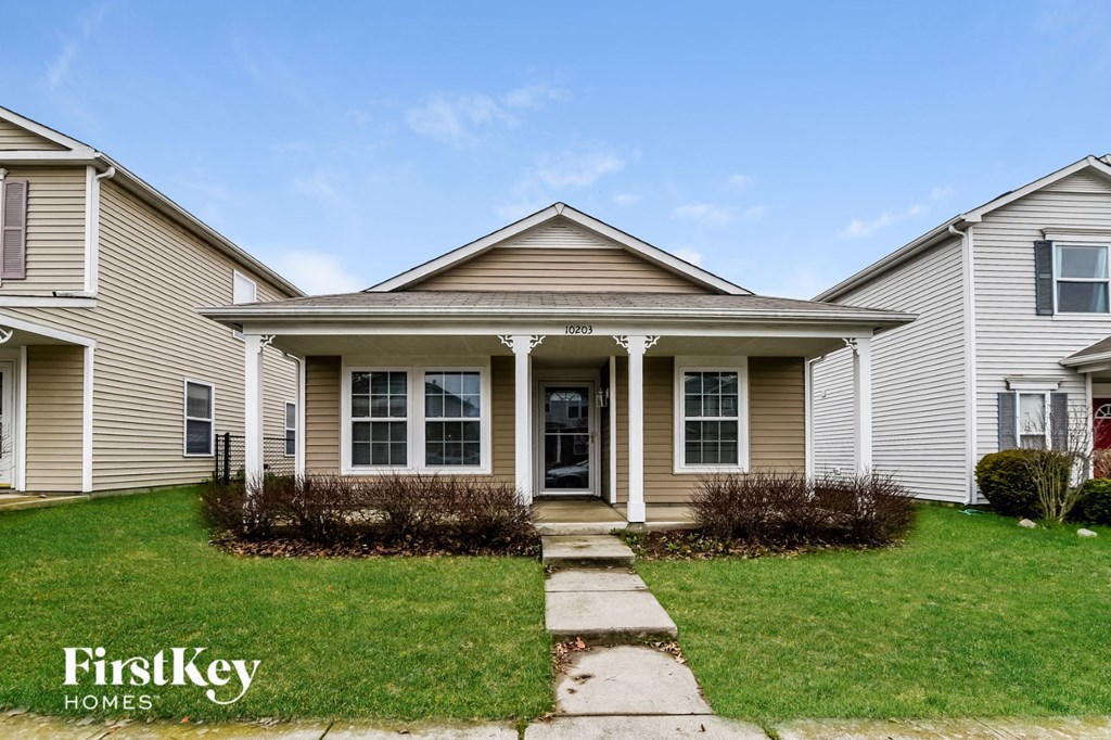 the front of a house with a lawn and walkway