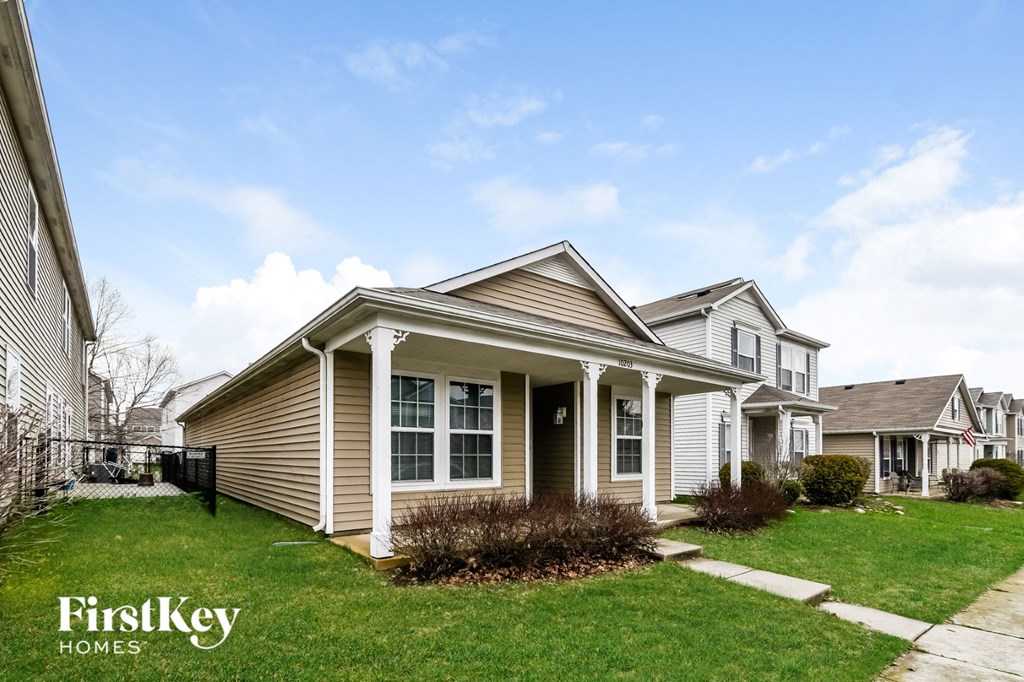 a home with a lawn and a sidewalk in front of it