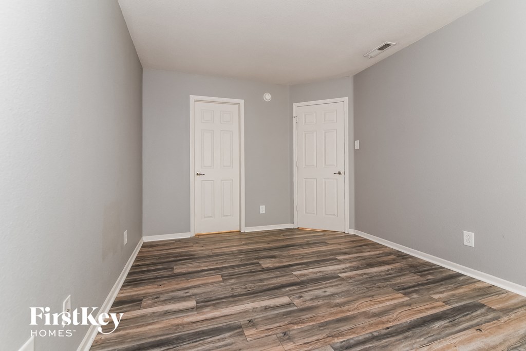 the living room of a home with grey walls and wood floors