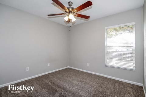 the living room of a home with a ceiling fan and carpet