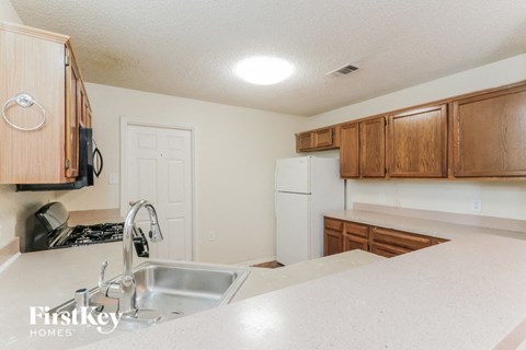 a kitchen with white appliances and wooden cabinets and a sink
