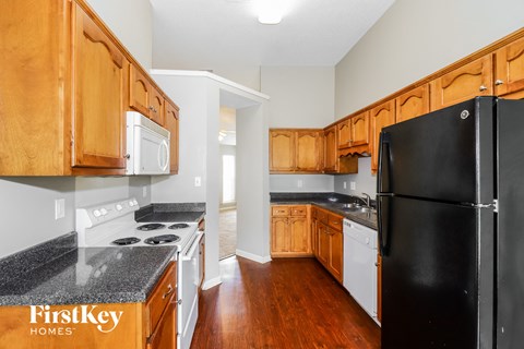 a kitchen with wooden cabinets and a black refrigerator
