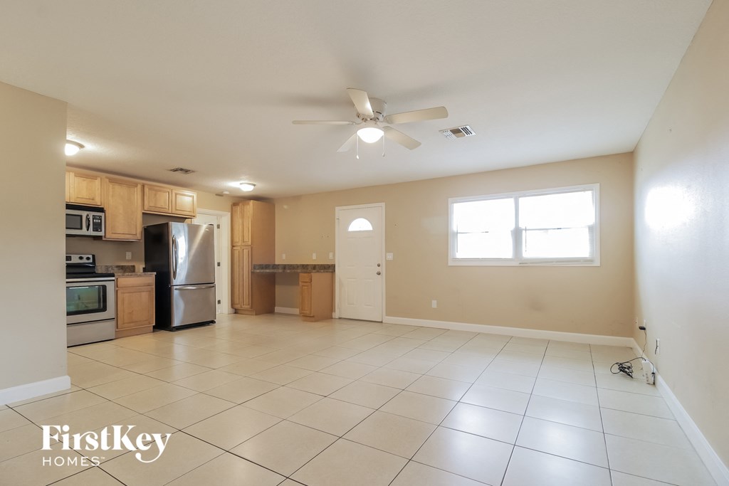 a large kitchen with tiled flooring and a ceiling fan