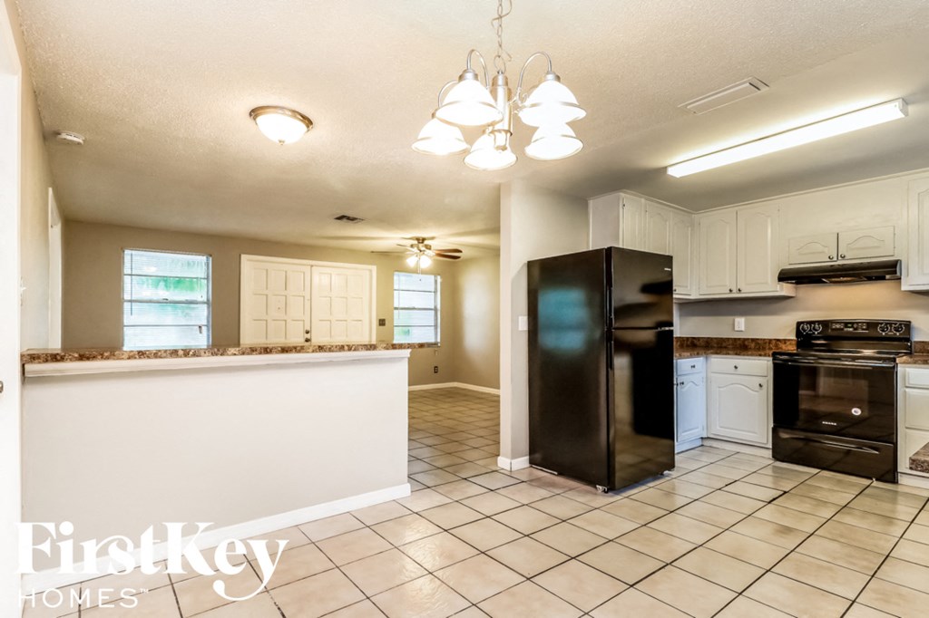 a kitchen with a counter top and a black refrigerator