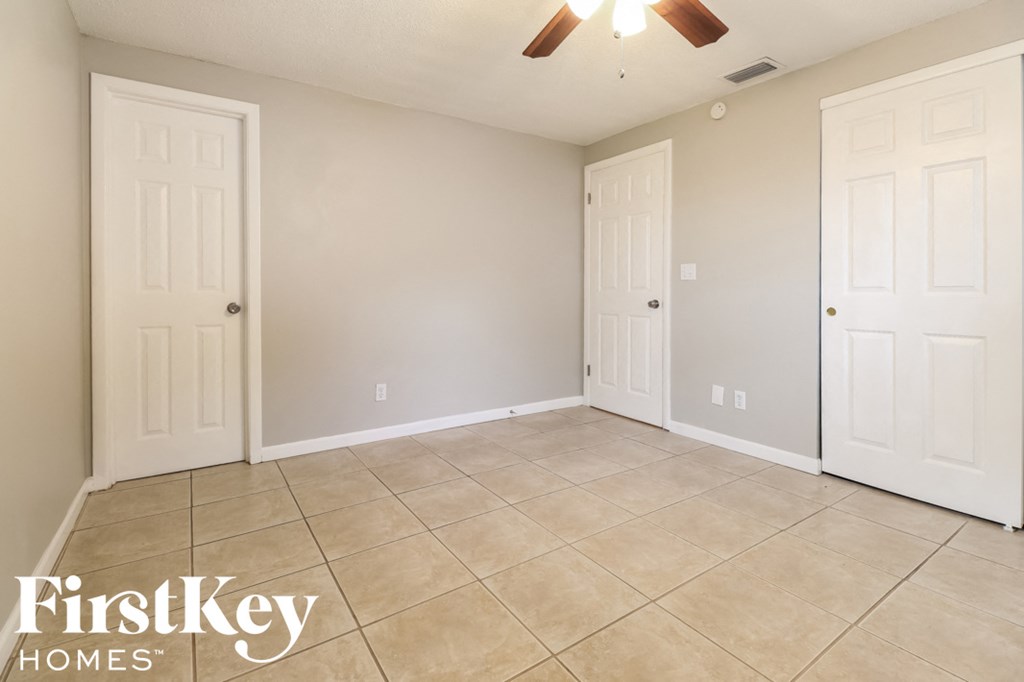 a empty room with two doors and a tile floor
