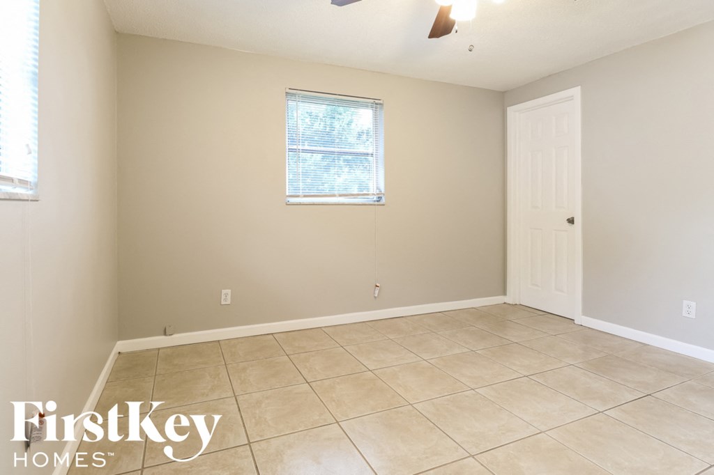 a empty living room with a tiled floor and a white door