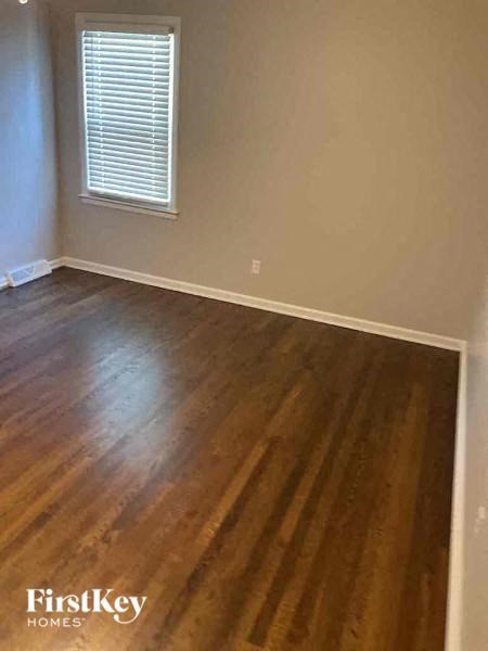 an empty room with wooden floors and a window