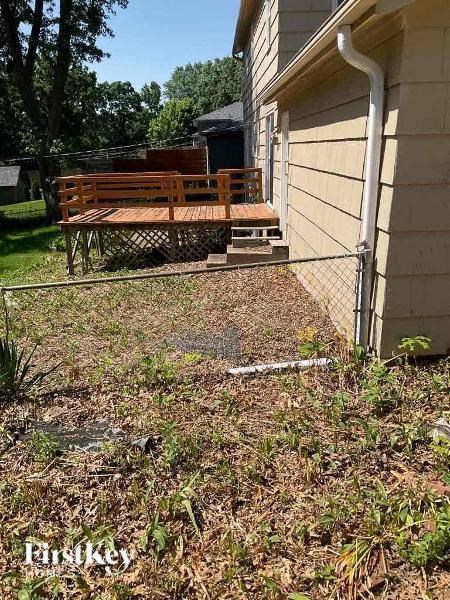 a backyard with a bench and a chain link fence