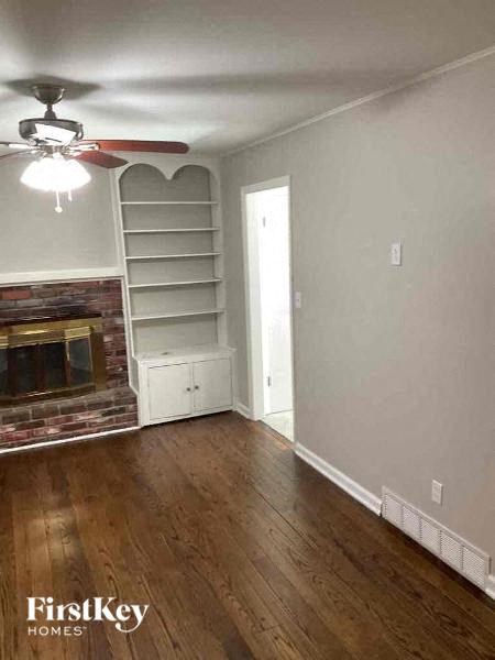 a living room with a fireplace and a ceiling fan