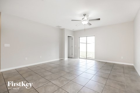 A spacious room with a ceiling fan and sliding glass doors.