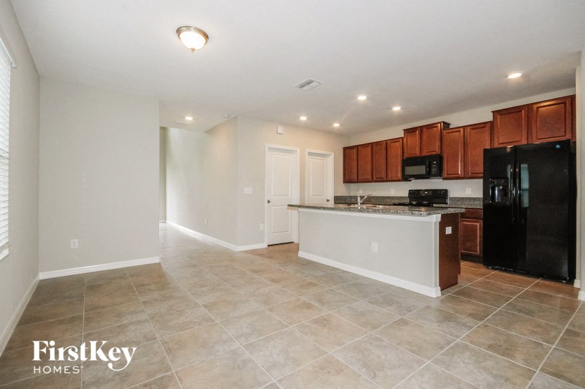 A kitchen with black appliances and wooden cabinets.