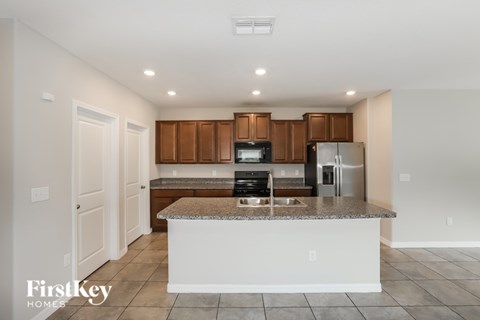 A kitchen with a white island and wooden cabinets.