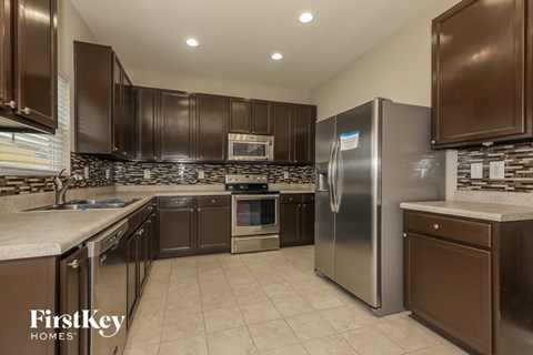 A kitchen with brown cabinets and a stainless steel refrigerator.