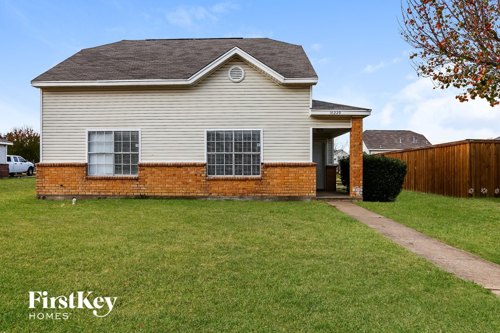 a white house with a yard and a wooden fence