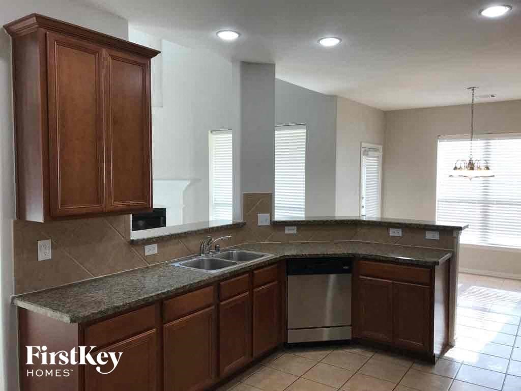 an empty kitchen with wooden cabinets and a sink