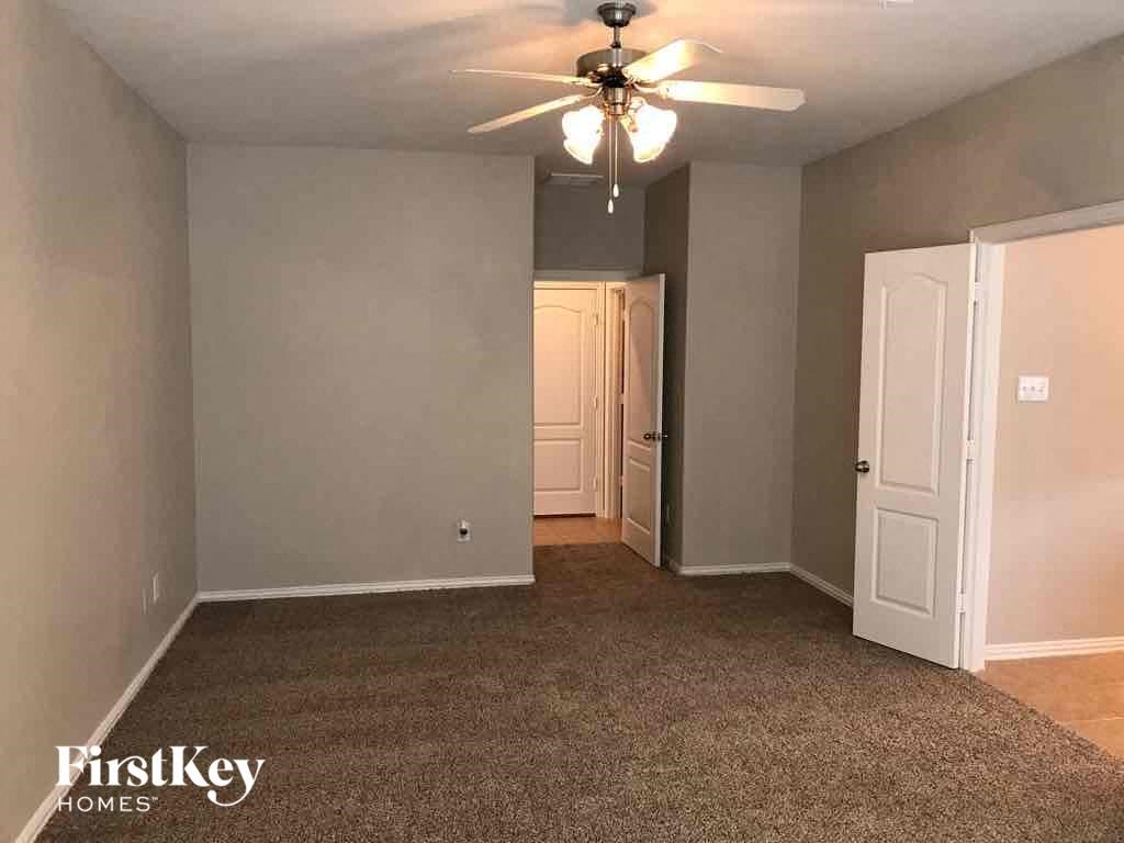 an empty living room with a ceiling fan