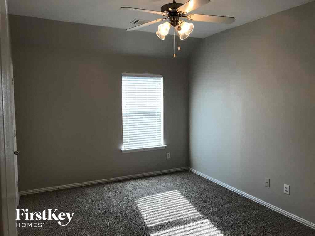 an empty room with a ceiling fan and a window