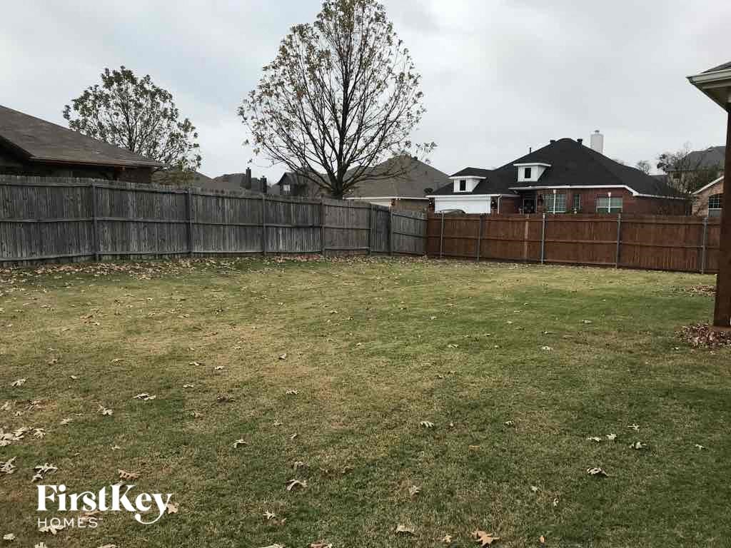 a fenced in backyard with a wooden fence
