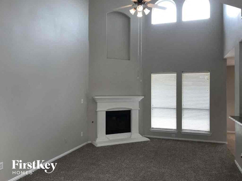 a living room with a fireplace and a ceiling fan