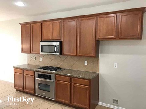 a kitchen with wooden cabinets and a stove and a microwave