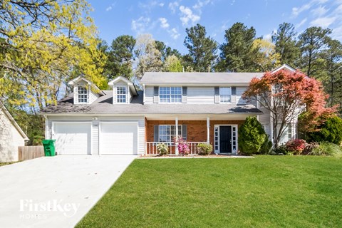 a white house with a lawn and a white garage door