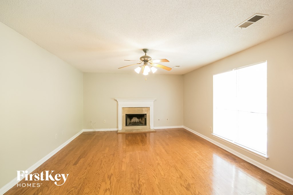 a living room with a fireplace and a ceiling fan