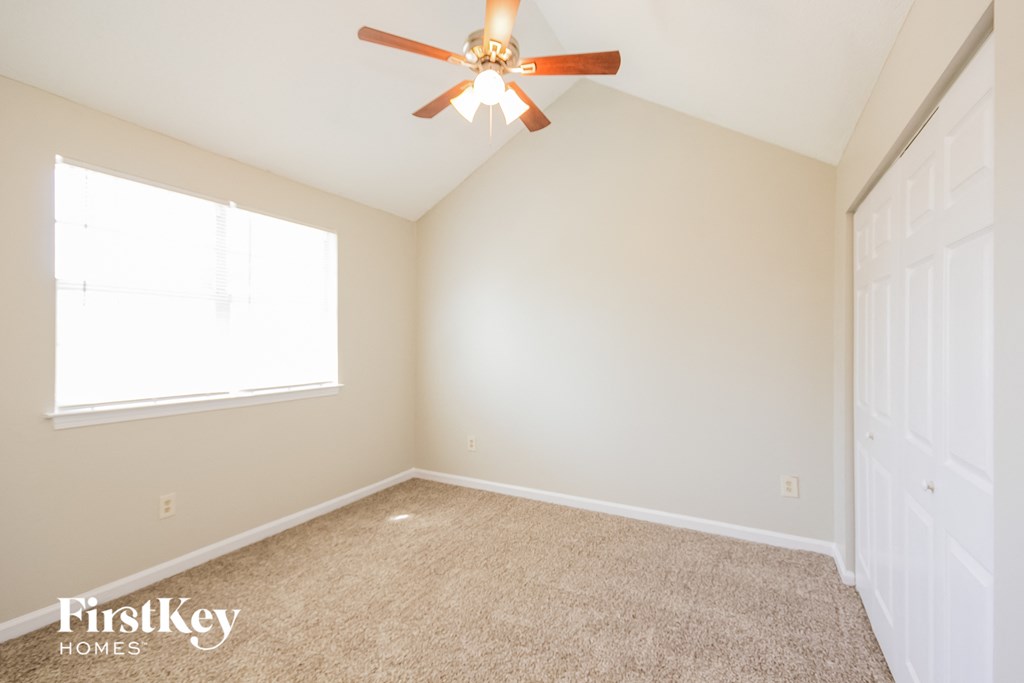 a bedroom with a ceiling fan and a window