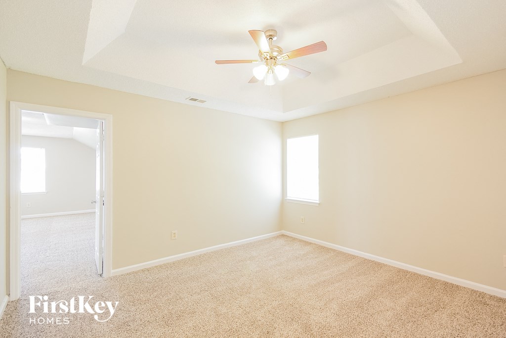a bedroom with carpet and a ceiling fan