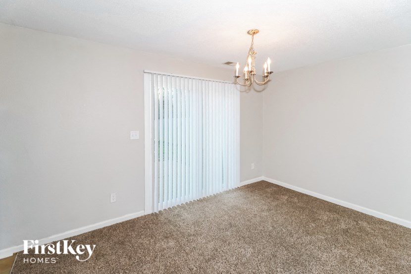 A room with a carpeted floor and a chandelier.