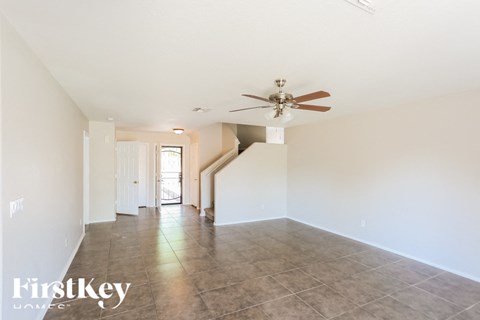 A spacious room with a fan and tiled floor.