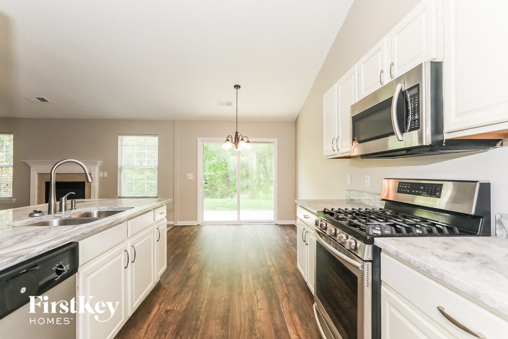 A kitchen with a stove top oven and a microwave.