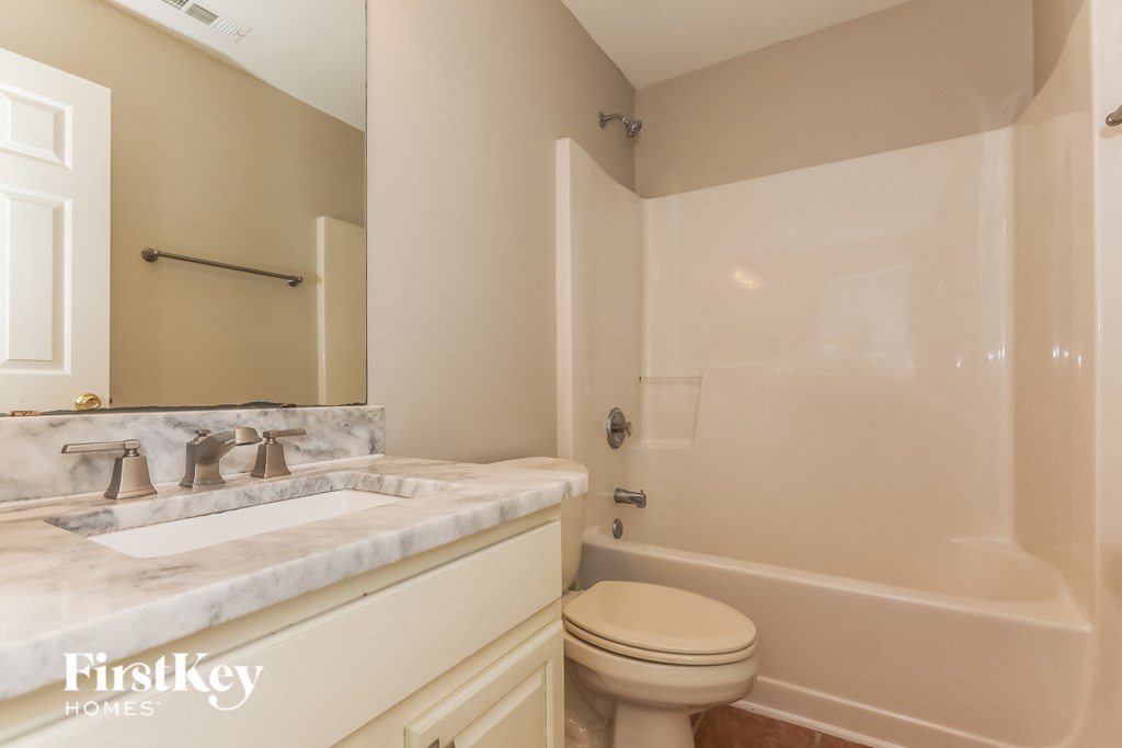 A bathroom with a marble sink and a toilet.