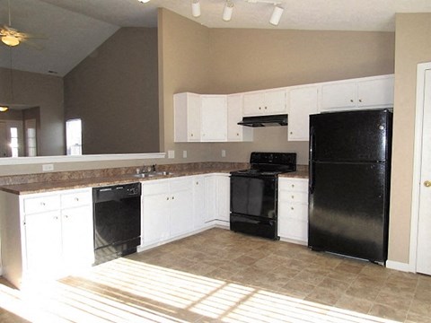 a kitchen with black appliances and white cabinets