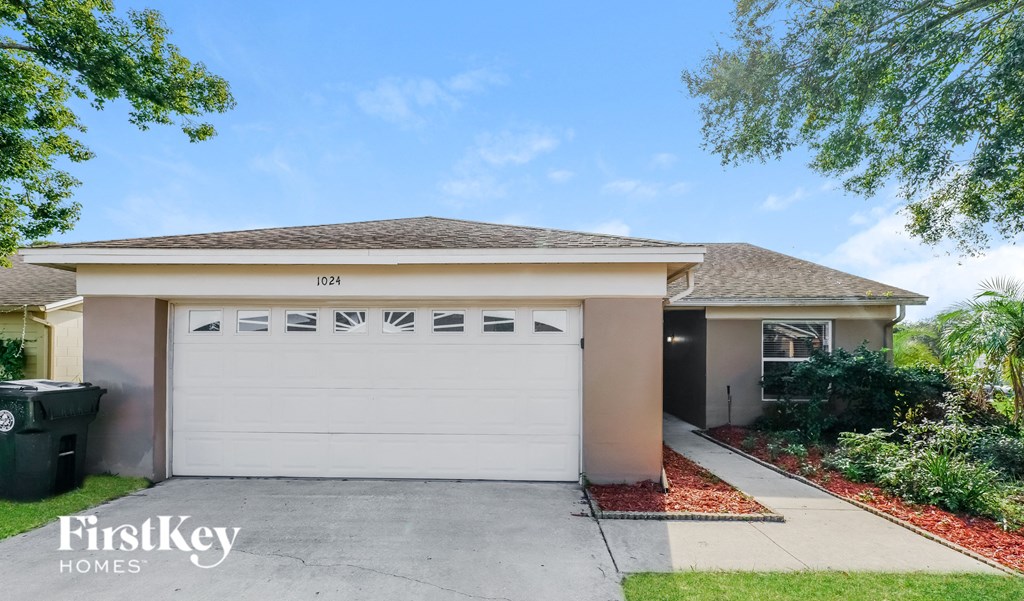 A house with a garage door numbered 1024 is for sale.