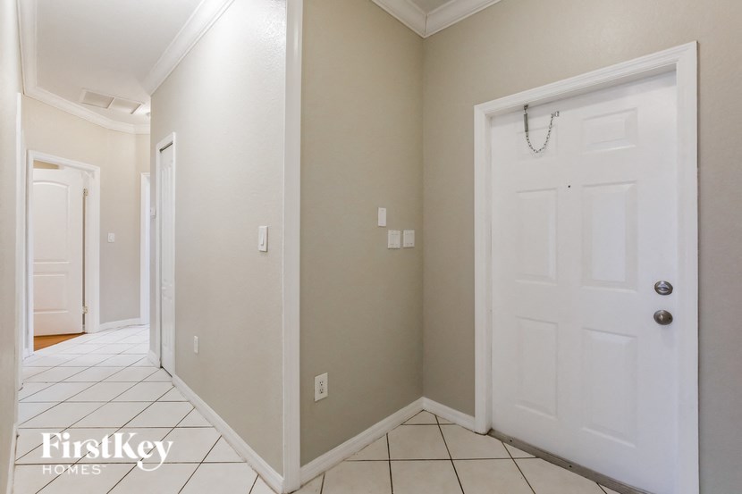 A white door is on the right side of a hallway.