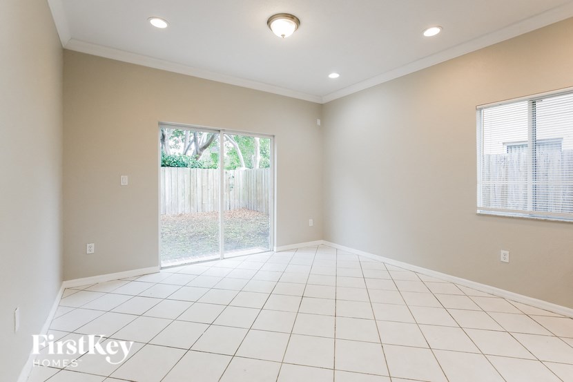 A spacious room with a sliding glass door leading to a backyard.