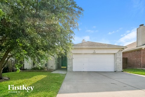 a house with a white garage door and a tree