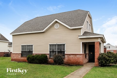 the front of a house with a brick porch and a sidewalk