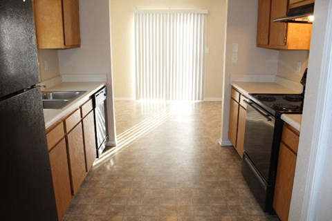 A kitchen with wooden cabinets and black appliances.