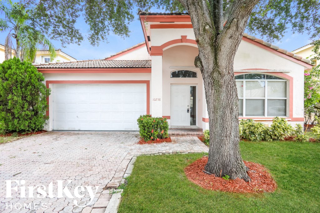 a home with a large tree in front of it