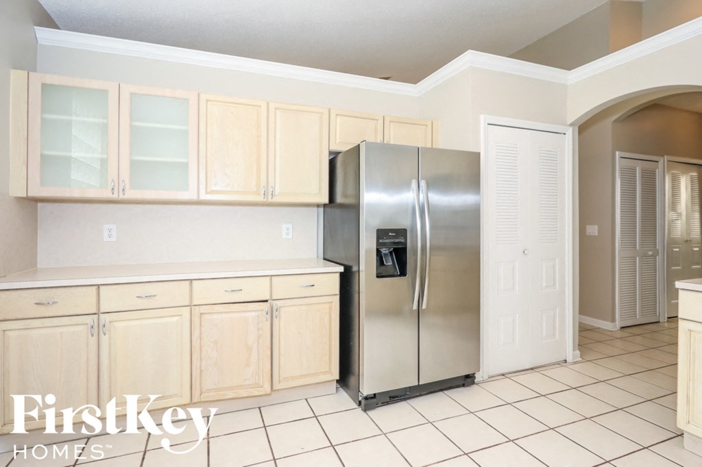 a kitchen with white cabinets and a stainless steel refrigerator