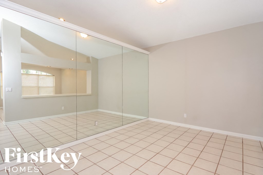a large room with a tiled floor and a large mirrored closet