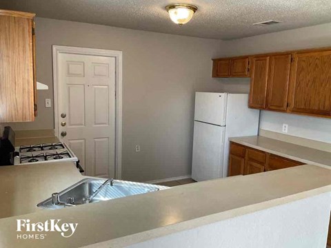 A kitchen with a stove top oven and a refrigerator.
