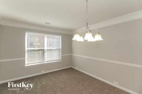 a dining room with three lamps and a window