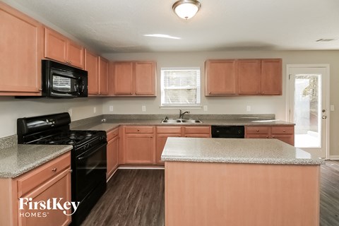a kitchen with wooden cabinets and black appliances and granite counter tops