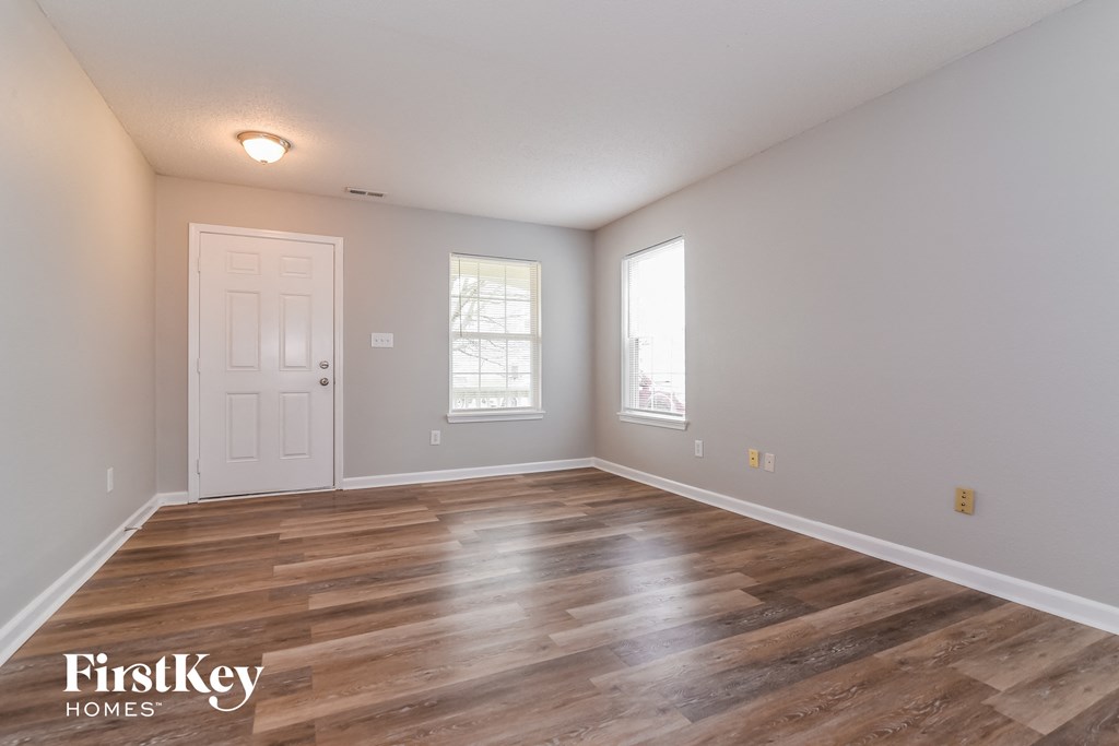 A room with wooden floors and a white door.