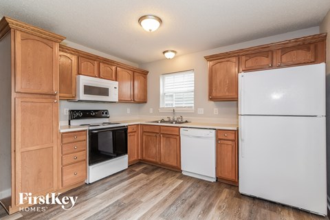 A kitchen with wooden cabinets and white appliances.