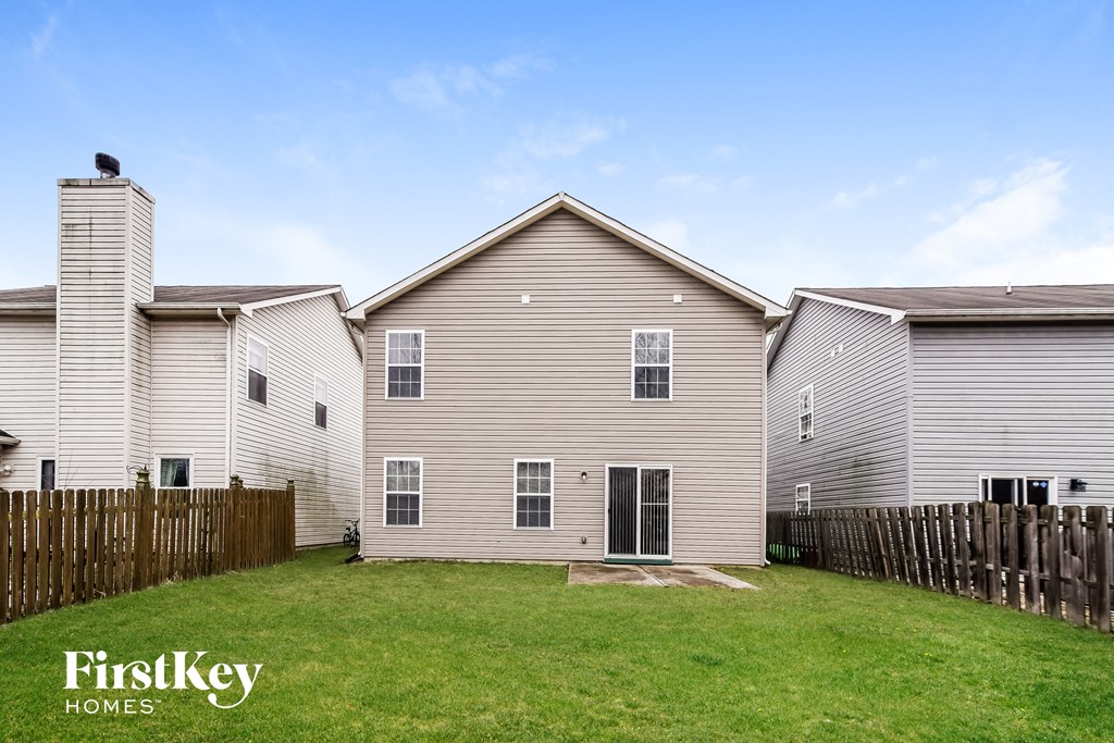 A house with a fence and a grassy yard.