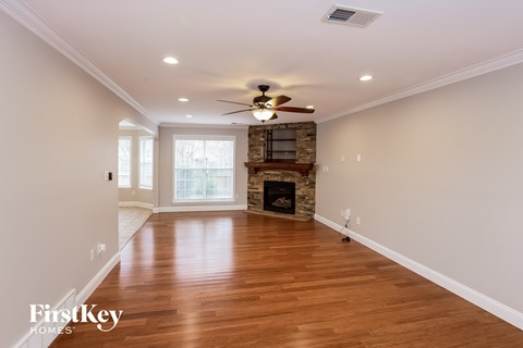 a living room with a fireplace and a ceiling fan