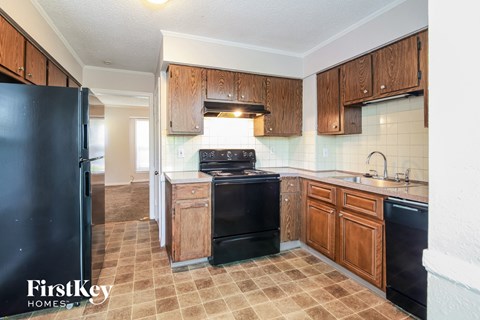 A kitchen with wooden cabinets and black appliances.
